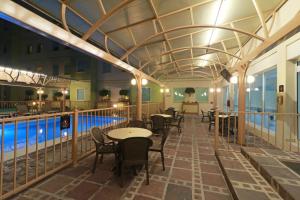 克雷塔罗克雷塔罗驻桥套房酒店的一间带游泳池和桌椅的餐厅
