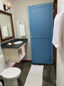 布罗塔斯Sítio Tamanduá的一间带卫生间和蓝色门的浴室
