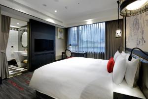 台北凯旋酒店的一间带白色大床的卧室和一间浴室