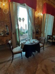 奥里斯塔诺Residenza d'Epoca Regina d'Arborea的一间带桌椅和窗户的用餐室