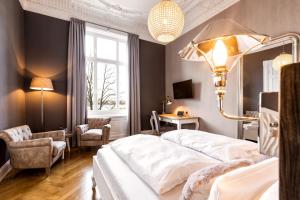 汉堡阿尔斯特布利克酒店的卧室配有一张白色大床和一把椅子