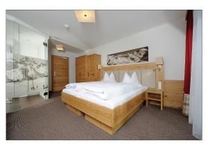 伊施格尔Apart Garni Schadhof的一间卧室配有一张带白色床单的大床