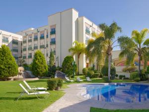 阿瓜斯卡连特斯美洲阿瓜斯卡连特斯嘉年华酒店的一个带游泳池和棕榈树的度假村