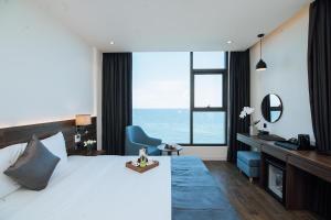 洞海Phương Bắc Luxury Hotel的一间卧室配有一张床、一张书桌和一个大窗户