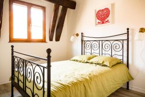 奥贝奈Résidence des Tanneurs - Sylvaner的一间卧室配有一张黑色床、黄色床单和窗户。