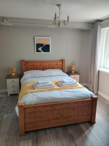 艾尔Anchors Away的一间卧室配有木床和2个床头柜