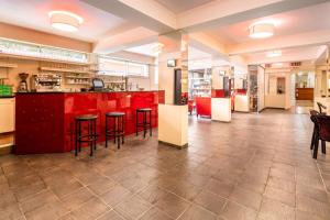 卢尔德夏天阿伊艾勒酒店的一间厨房,配有红色橱柜和酒吧凳子