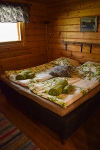 HiukkajokiPuruvesi Holiday Villas, Kalliohovi的木墙客房的一张床位