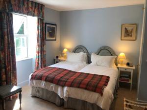 巴恩斯特珀尔霍拉摩尔农场住宿加早餐旅馆的一间卧室配有一张带白色床单的床和一扇窗户。