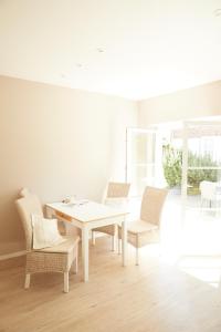 滕宁Ferienwohnungen Zum Goldenen Anker的白色的用餐室配有白色的桌椅