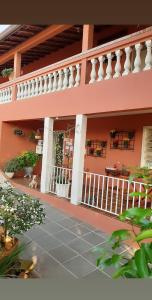 阿瓜斯-迪圣佩德罗Piccola Pousada的粉红色的房子,设有门廊和阳台