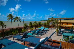 若昂佩索阿Hotel do Mar Cabo Branco的一个带蓝色椅子的甲板和海滩