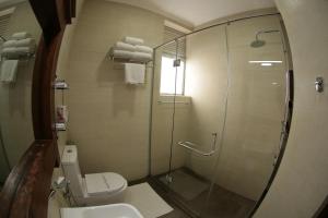 康提皇家购物中心酒店的一间带卫生间和玻璃淋浴间的浴室