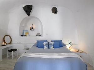 易莫洛林Altana Heritage Suites的白色卧室配有蓝色的床和蓝色枕头