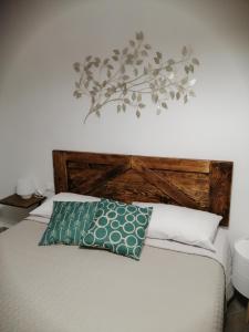皮昂比诺Tre Orologi的一张带木制床头板和绿色枕头的床