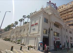 亚历山大Royal Jewel Al Raml Hotel的街道边的白色大建筑