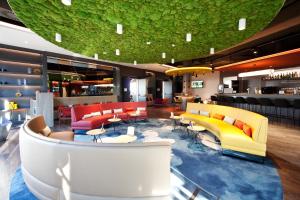 帕恩多夫ibis Styles Parndorf Neusiedler See的大堂设有色彩缤纷的家具和酒吧