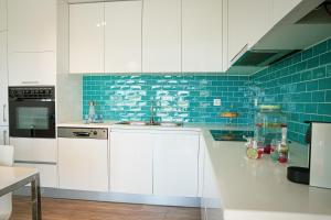 费雷尔Marlin House IV的厨房配有白色橱柜和蓝色瓷砖
