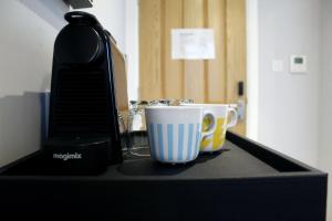 伦敦CG Kensington的咖啡壶和柜台上的两个咖啡杯