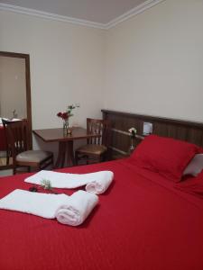 瓦尔任阿大埃尼奥酒吧酒店的一间卧室配有红色的床和毛巾