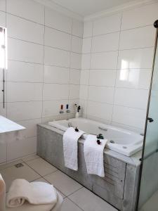 瓦尔任阿大埃尼奥酒吧酒店的白色的浴室设有浴缸和2条毛巾。