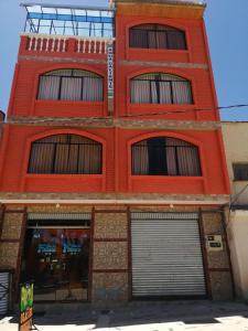 科帕卡巴纳Hostal Olas Del Titicaca的红砖建筑,设有两扇车库门