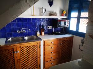 弗里希利亚纳Casa David的厨房配有水槽和蓝色的瓷砖墙壁