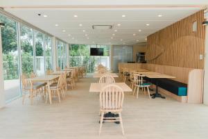 北碧Erachon Raft Resort的餐厅设有木桌、椅子和窗户。