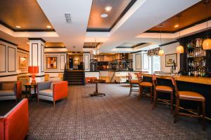 夏洛特登喜路酒店的餐厅设有酒吧,配有一些桌椅