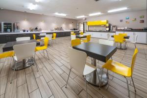康瑟尔布拉夫斯BridgePointe Inn & Suites by BPhotels, Council Bluffs, Omaha Area的用餐室配有桌子和黄色椅子