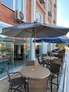 布卢梅瑙Hotel Himmelblau的庭院内桌椅和遮阳伞