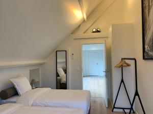 德哈恩Villa Zuid的阁楼卧室配有两张床和镜子