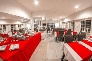 米娜克拉韦罗卡萨布兰卡酒店的一间餐厅,房间内设有红色的桌椅