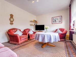 梅德巴赫Apartment with terrace in Sauerland region的客厅配有红色椅子和桌子