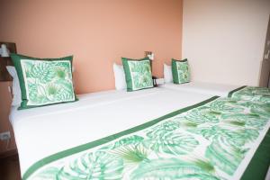 帕皮提塔希提岛机场汽车旅馆的一张带绿色和白色床单及枕头的床