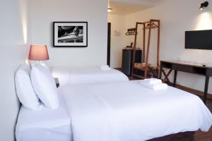 清迈La Mai Hotel的酒店客房配有两张床和一张书桌