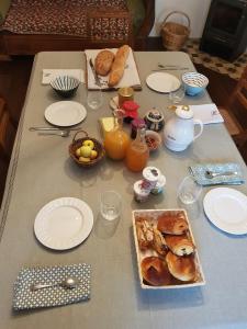 RougegoutteLe jardin des gouttes的餐桌,早餐包括羊角面包、面包和果汁