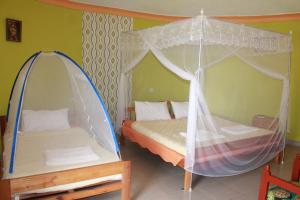 卡巴莱Crater Bay Cottages的一间卧室配有两张床和一张天蓬床。
