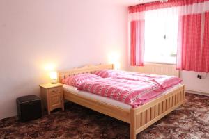 BrtniceChalupa u Smolíků的一间卧室配有一张带粉色床单的床和一扇窗户。