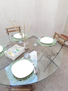 穆尔西亚Apartamento San Juan 1的一张玻璃桌,配有两把白板和椅子