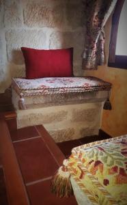 Baños de Rioja托雷富尔特S.XIII中世纪乡村旅馆的一张床上,有红色枕头,放在房间里