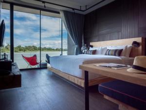 北碧Cross River Kwai的一间卧室设有一张大床和一个大窗户