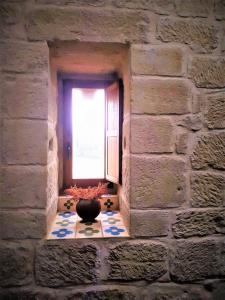 Baños de Rioja托雷富尔特S.XIII中世纪乡村旅馆的砖墙上的窗户,桌子上有一个花瓶