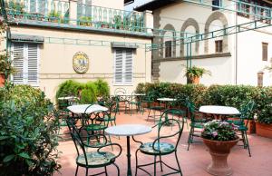 佛罗伦萨贝尔基耶利酒店的庭院内带桌椅的庭院。