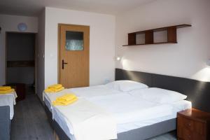 斯维诺乌伊希切Graal SPA的一间卧室配有两张带黄毛巾的床。