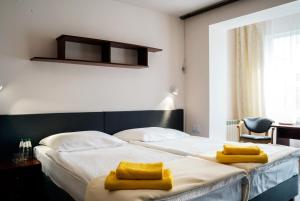 斯维诺乌伊希切Graal SPA的一间卧室配有一张大床,床上配有黄色毛巾