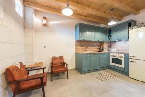 奈维丹Holiday Home Lipa Naša的厨房配有蓝色橱柜、桌子和椅子