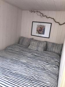 格里姆斯塔Hytte med sjøutsikt og 20 min fra dyreparken的一张带条纹床单的床和墙上的照片
