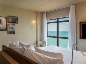 累西腓累西腓博阿维亚任美居酒店的一间卧室设有一张床,享有海景