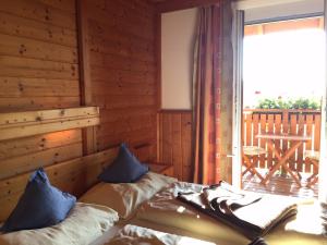 德意志兰茨贝格Bio - Hotel - Alpengasthof Koralpenblick的一间卧室设有一张床和一个带甲板的窗户